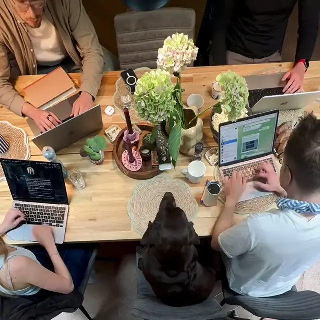 People working on laptops around one table, seen from above.