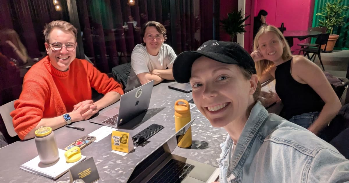 Four founders smiling at one table with laptops during a Limen session in Amsterdam.