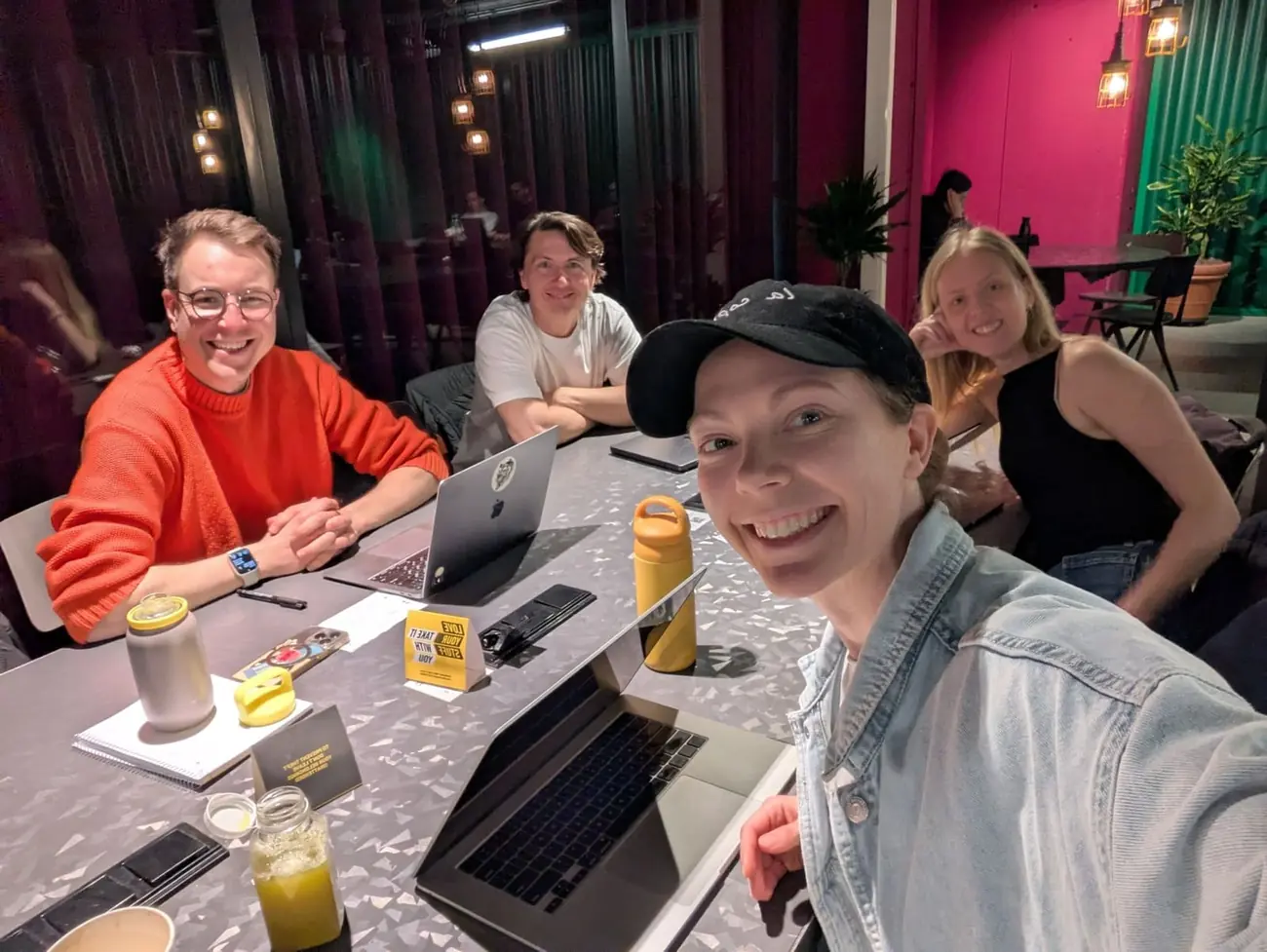 Four members smiling around one table between focus blocks